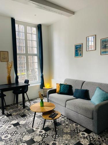 un salon avec un canapé et une table dans l'établissement Le Rituel St Maclou, hyper centre vue sur église, à Rouen