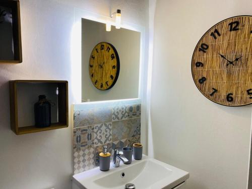 a bathroom with a sink and a clock on the wall at Le Rituel St Maclou, 4 pers Quartier historique in Rouen