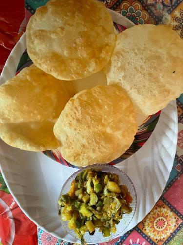 a plate of food with pita bread and a bowl of dips at Veda Home's in Agartala