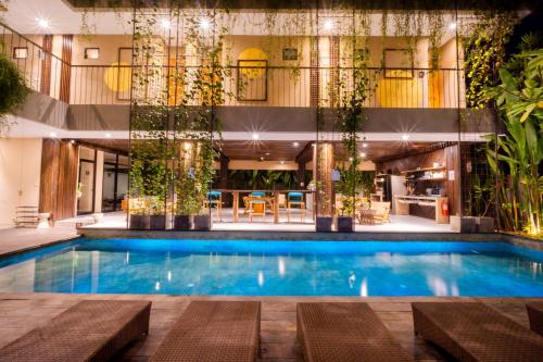 a swimming pool with plants in a building at Tanaga CoLiving in Seminyak