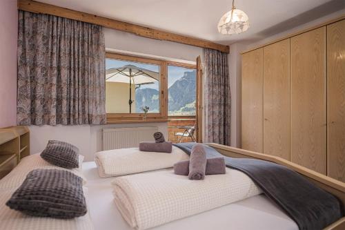 2 letti in una camera da letto con finestra di Apart. Mountainlovers a Hainzenberg