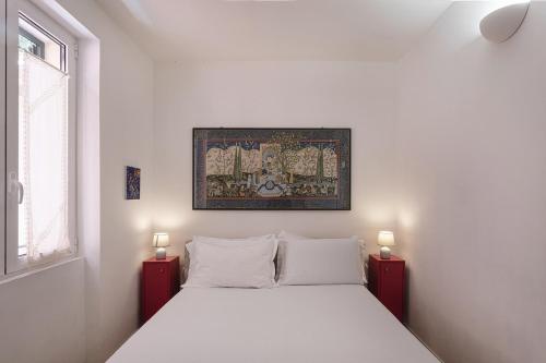 Casa Artè by Wonderful Italy في سانتا مارغريتا ليغور: غرفة نوم بسرير ابيض وصورة على الحائط