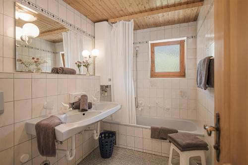 a white bathroom with a sink and a bath tub at Apart. Mountainlovers in Hainzenberg