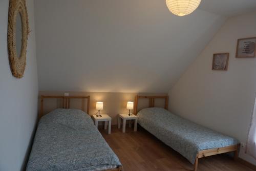 2 Betten in einem Dachzimmer mit 2 Lampen in der Unterkunft Entre vignes et châteaux - charmante maison au calme, idéale pour famille ou entre amis - parking gratuit in Dieffenthal
