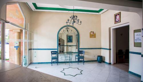 a room with a table and chairs and a mirror at Hôtel Olympic in Fez