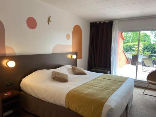 MontignyにあるLogis Hôtel & Restaurant - Le Relais de Montignyのベッドと大きな窓のある寝室