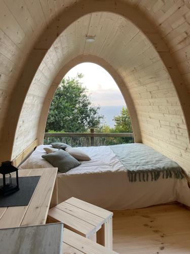2 camas en una habitación de ladrillo con un arco en Camping Santa Elena en Mutriku