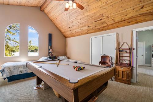 una mesa de billar en una habitación con cama y ventanas en Marina Beach Lodge - Lakefront Home on Beach! home en Groveland