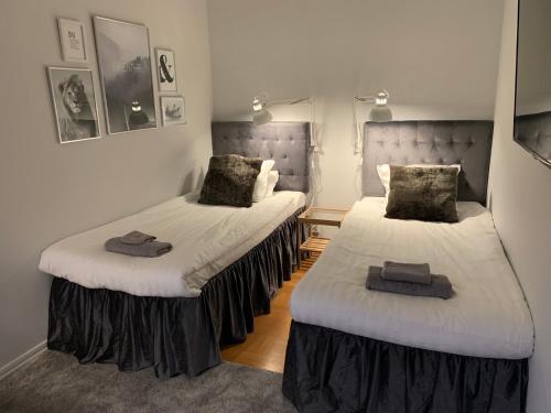 a room with two beds with white sheets at Kungälv Longstay in Kungälv