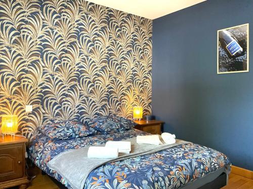- une chambre dotée d'un lit avec du papier peint bleu et or dans l'établissement Le Gîte des Bénédictins, à Hautvillers