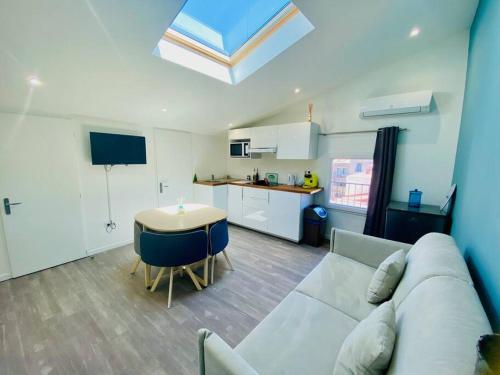 un salon avec un canapé et une table et une cuisine dans l'établissement ''L'Amandier'' Cosy T2 en coeur de ville, climatisé, à Sète