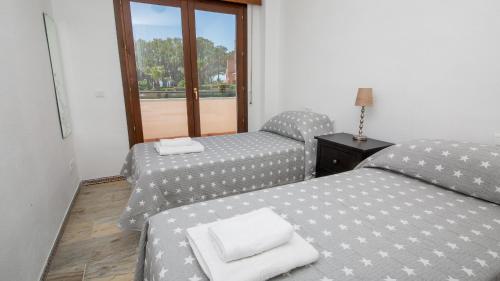 2 camas individuales en una habitación con ventana en La Borboleta 8, en Manilva