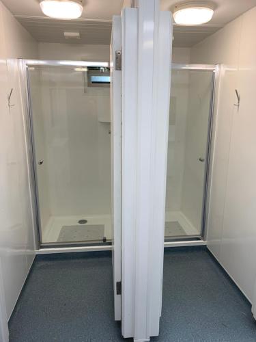 a walkin closet with a glass door in a room at Cow Close Camping Pods in Leyburn