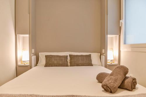 a bedroom with a large white bed with two lamps at MAGNÍFICO APARTAMENTO - primera línea de mar in Calafell