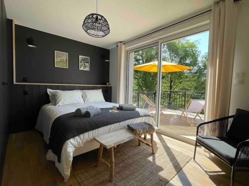 1 dormitorio con 1 cama y balcón con sombrilla en Domaine de 6 hectares avec 2 étangs que pour vous, en Nontron