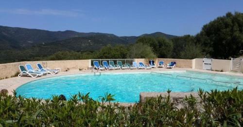 a large swimming pool with blue chairs at MAISON ALBA ROSSA 55 in Serra-di-Ferro