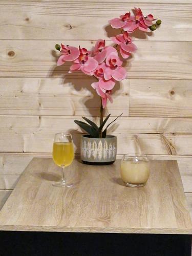 une table avec deux verres et un vase avec des fleurs dans l'établissement Haut Doubs Plaisir, SPA, à Chamesol