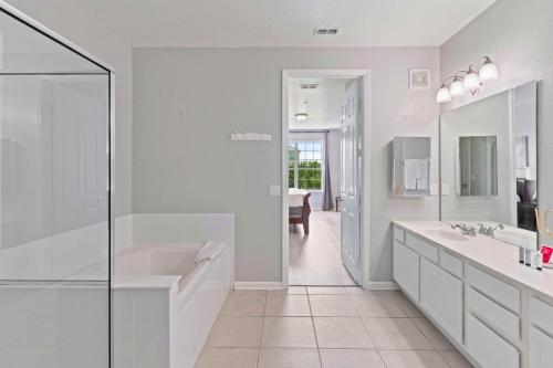 4804 Cayview Avenue 305 في أورلاندو: حمام أبيض مع حوض استحمام ومغسلة