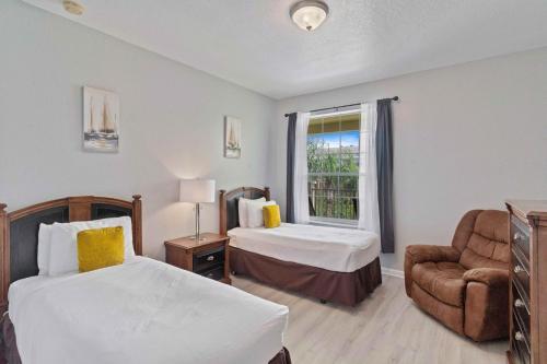 4804 Cayview Avenue 305 في أورلاندو: غرفة نوم بسريرين وكرسي ونافذة