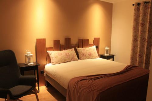 a bedroom with a bed and a chair at Casa do Centro in Pessegueiro