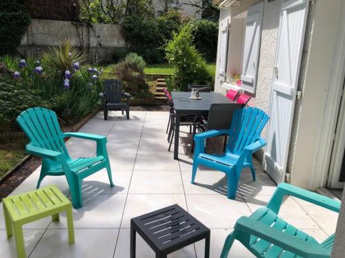 d'une terrasse avec des chaises colorées, une table et des chaises. dans l'établissement La chambre bleue, à Jard-sur-Mer