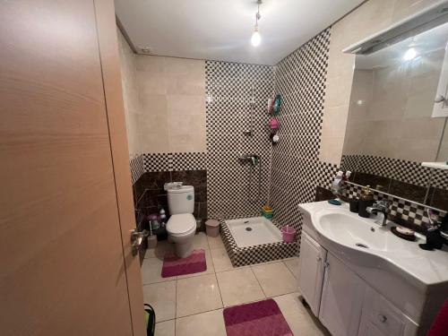 ein Badezimmer mit einem WC, einem Waschbecken und einem Spiegel in der Unterkunft مدينة أصيلة قرب طريق السيار طنجة المغرب in Asilah