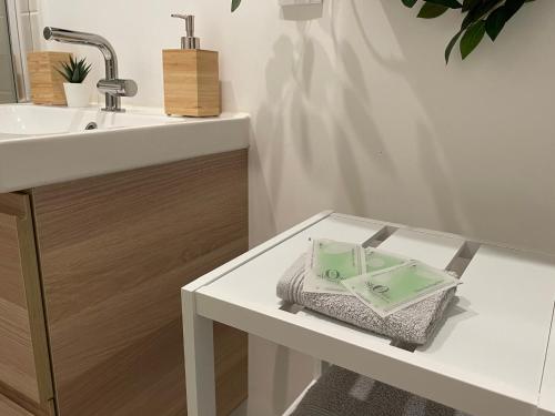 a bathroom with a sink and a white table at Studio Le Cilaos, au cœur de Castres in Castres