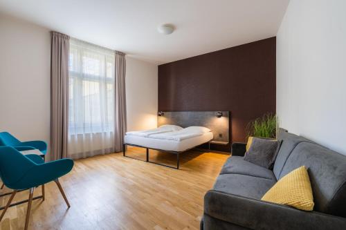 a living room with a couch and a bed at EA ApartHotel Melantrich in Prague