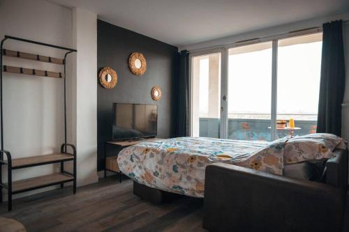 een slaapkamer met een bed, een bureau en ramen bij Le Rose - Centre Ville - Wifi in Duinkerke