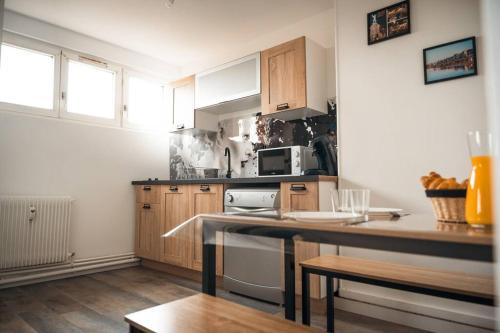 une cuisine avec une cuisinière et un micro-ondes dans l'établissement Le Rose - Centre Ville - Wifi, à Dunkerque