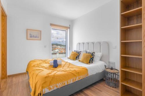 een slaapkamer met een groot bed en een raam bij Apartamento Figueiras in Nazaré