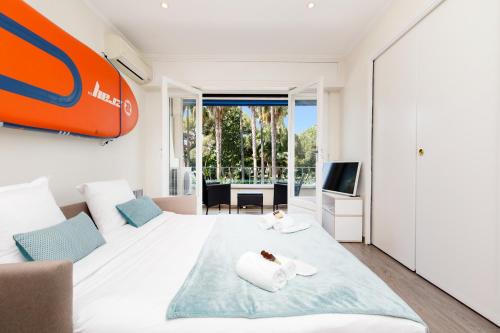 um quarto com uma cama grande e uma televisão em Les 3 Palmiers YourHostHelper em Cannes