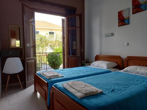 Un dormitorio con dos camas y un balcón. en KOSTAS APARTMENTS, en Sidari