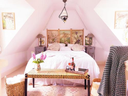Un dormitorio con una cama y una mesa con bebidas. en Kipling Cottage, en Burwash