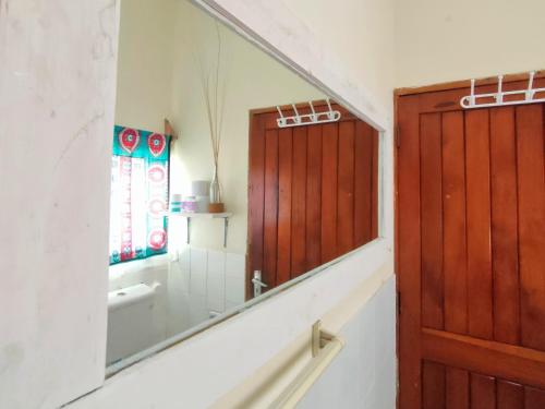 a bathroom with a large mirror and a sink at Palm Paradise Loft in Diani Beach