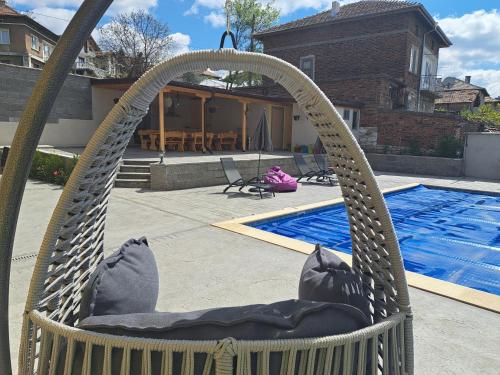 uma cadeira de rede em frente a uma piscina em Sunset view guest house em Ilindentsi