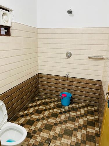 uma casa de banho com WC e um balde azul em Flowers Villa em Ambalavayal