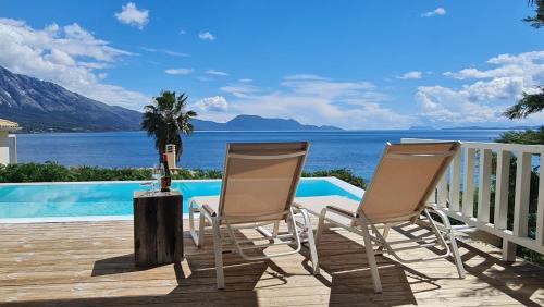 2 sillas en una terraza con vistas al océano en Villa Kalamos, beachfront, en Pogoniá