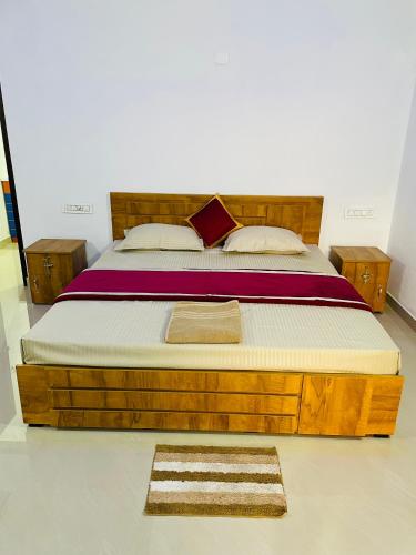 uma cama com uma estrutura de madeira num quarto em Flowers Villa em Ambalavayal