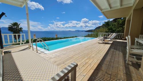 una terraza con piscina y vistas al agua en Villa Kalamos, beachfront, en Pogoniá