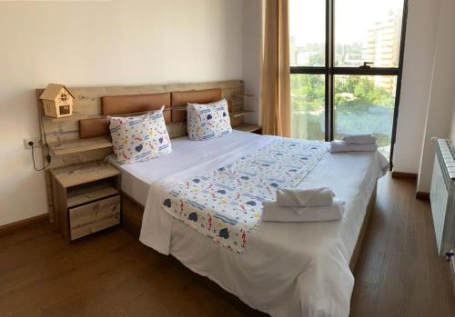 a bedroom with a large bed and a window at City Central Apartment in Yerevan
