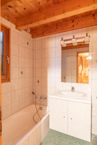 une salle de bain avec une baignoire et un lavabo dans l'établissement Chalet Le Lapye, aux Gets