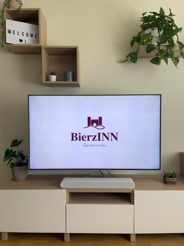 TV de pantalla plana grande en un centro de entretenimiento blanco en BierzINN apartamento, en Ponferrada