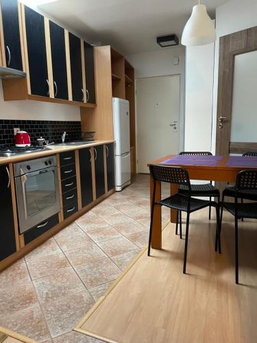 cocina con mesa, sillas y nevera en Apartament Bankowa Klimt, en Toruń