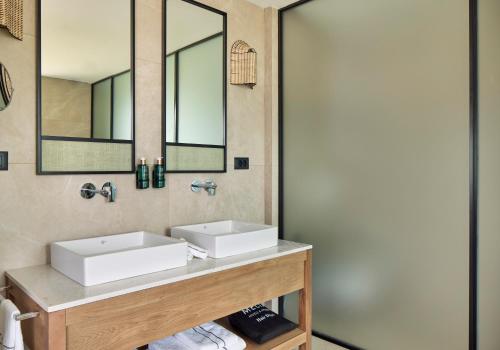a bathroom with two sinks and a mirror at Meliá Durrës Albania in Durrës