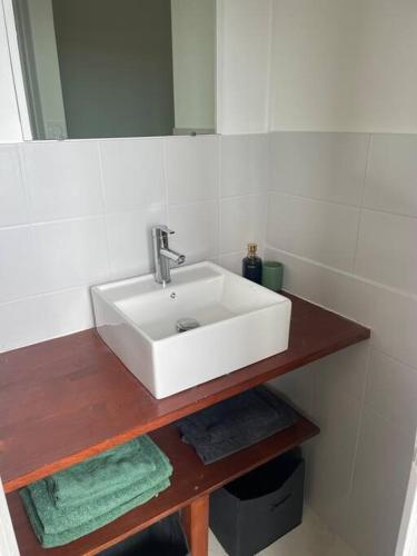 une salle de bain avec un lavabo blanc et un miroir dans l'établissement Proche des plages - Beau T2 climatisé, à Narbonne