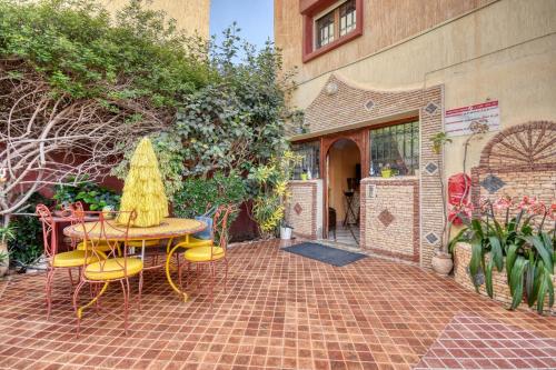 a patio with a table and chairs and a building at Villa Eden - Piscine - 8PX in Tamraght Ouzdar