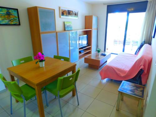 a room with a table and chairs and a bedroom at GMID IMMO Apartment Mileni in Roses