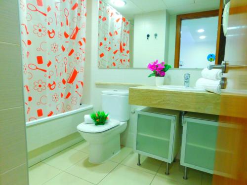 a bathroom with a toilet and a sink and a shower curtain at GMID IMMO Apartment Mileni in Roses