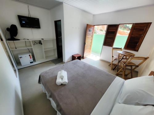 a bedroom with a bed with two white towels on it at Pousada Maria do Ceú in Guaramiranga